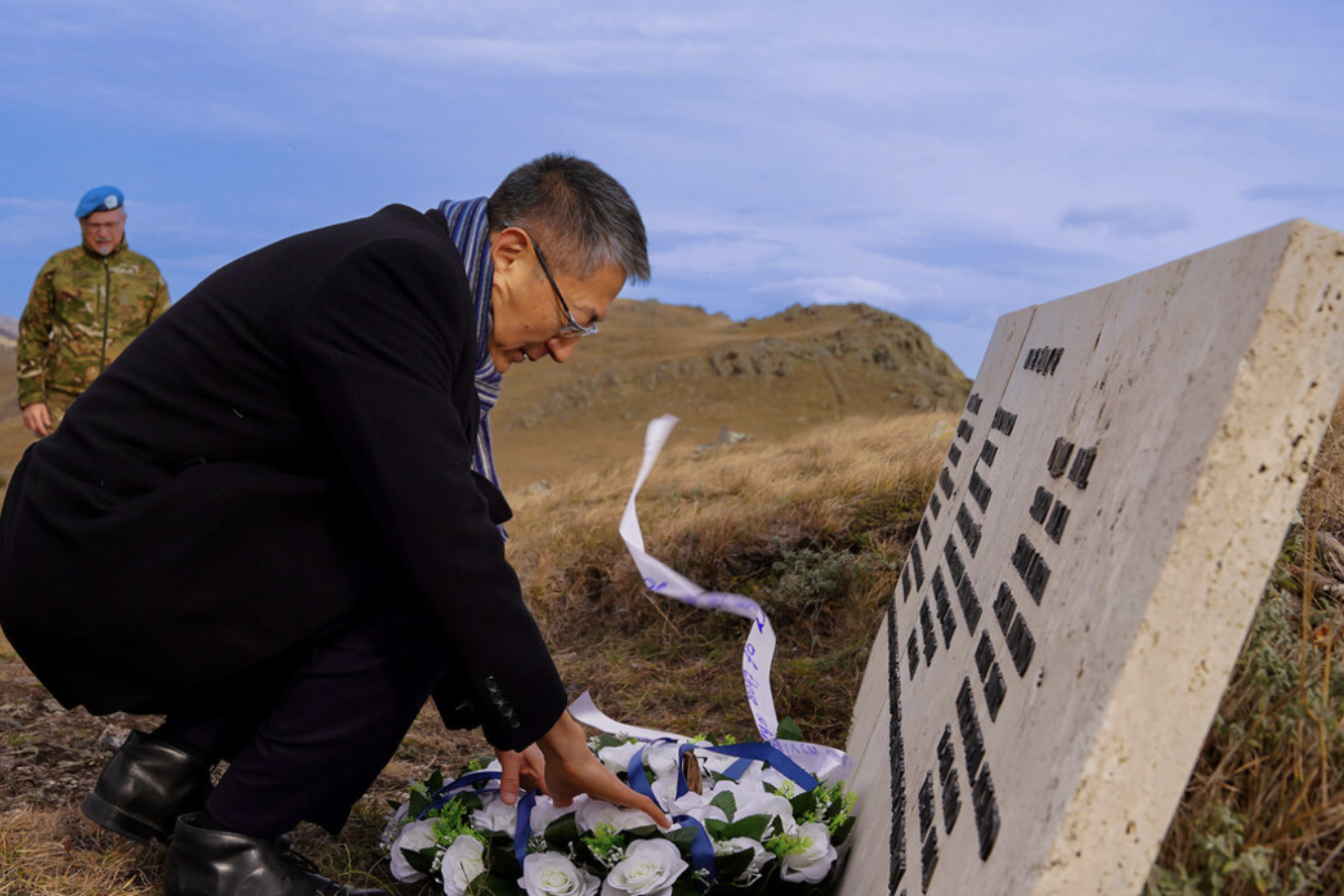 Man placing flowers on grave