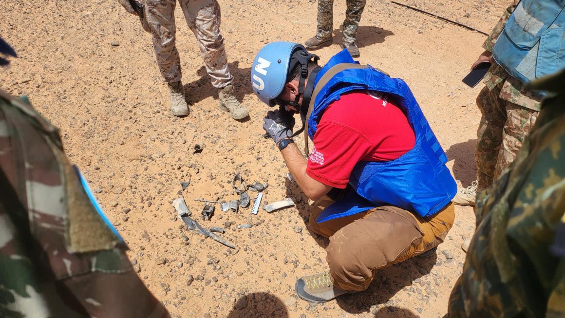 A UN de-miner inspects some explosive remnants of war in the desert